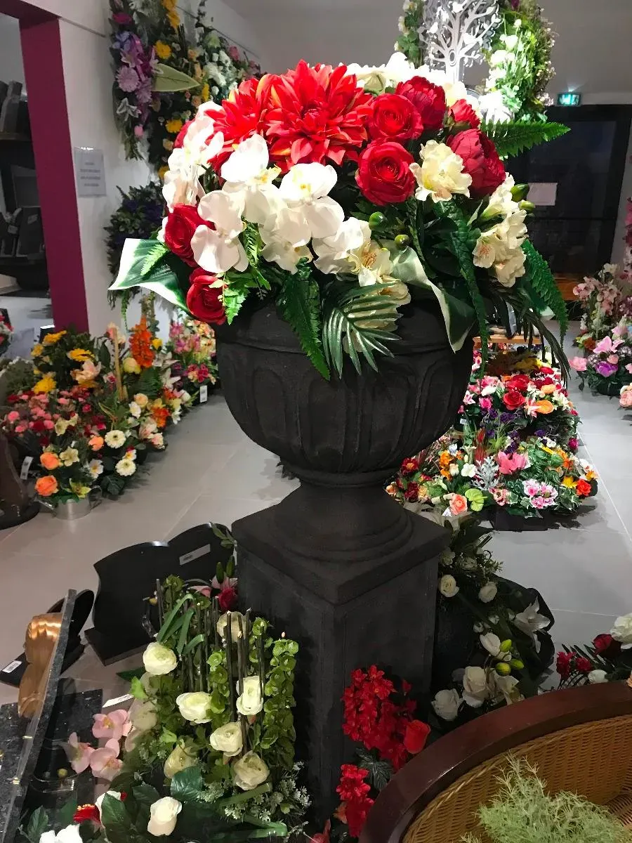 Vase médicis imposant garni d'une grande composition florale.