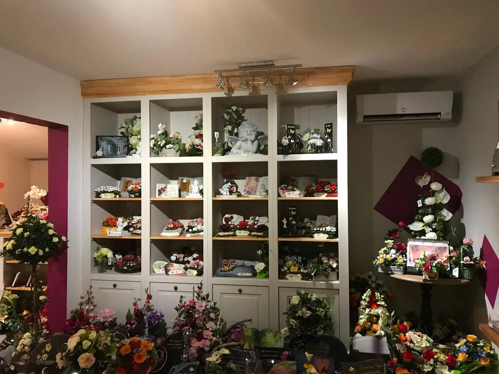 Étagères d'exposition présentant des plaques et articles funéraires.