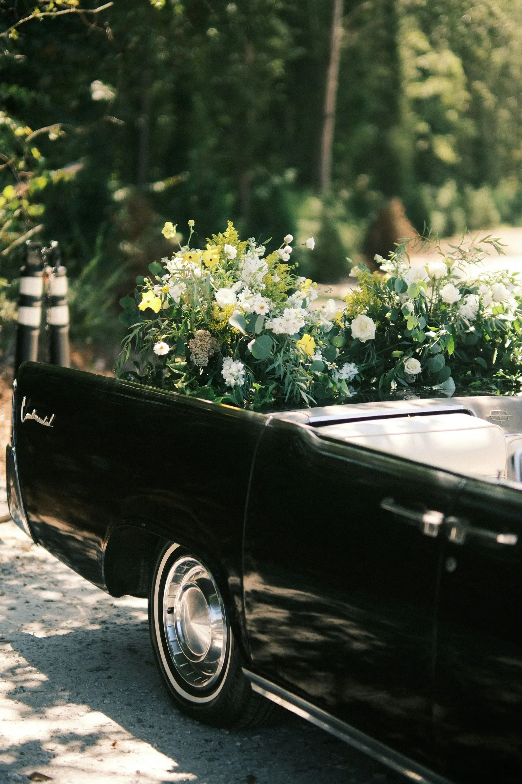 Véhicule funéraire ancien transportant des compositions florales.