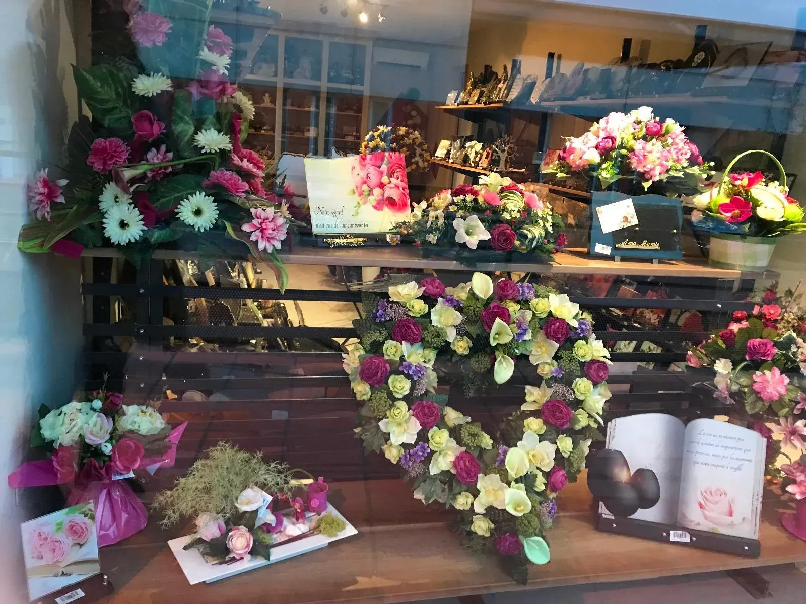 Vitrine funéraire proposant des couronnes en cœur et fleurs de souvenir.